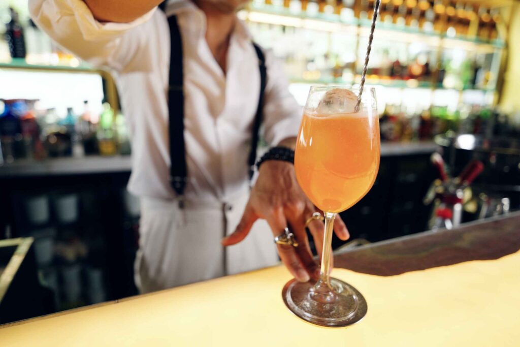 Bartender serving an elegant cocktail at a stylish bar counter Singapore nightlife