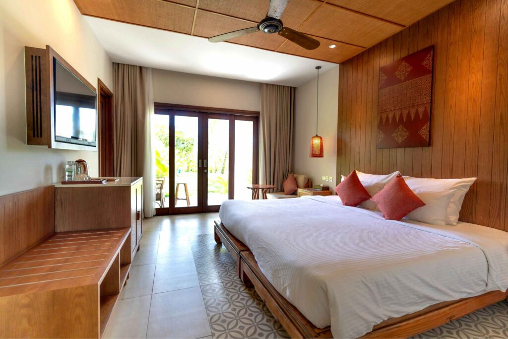 Elegant hotel room with double bed wooden floors and balcony doors Singapore