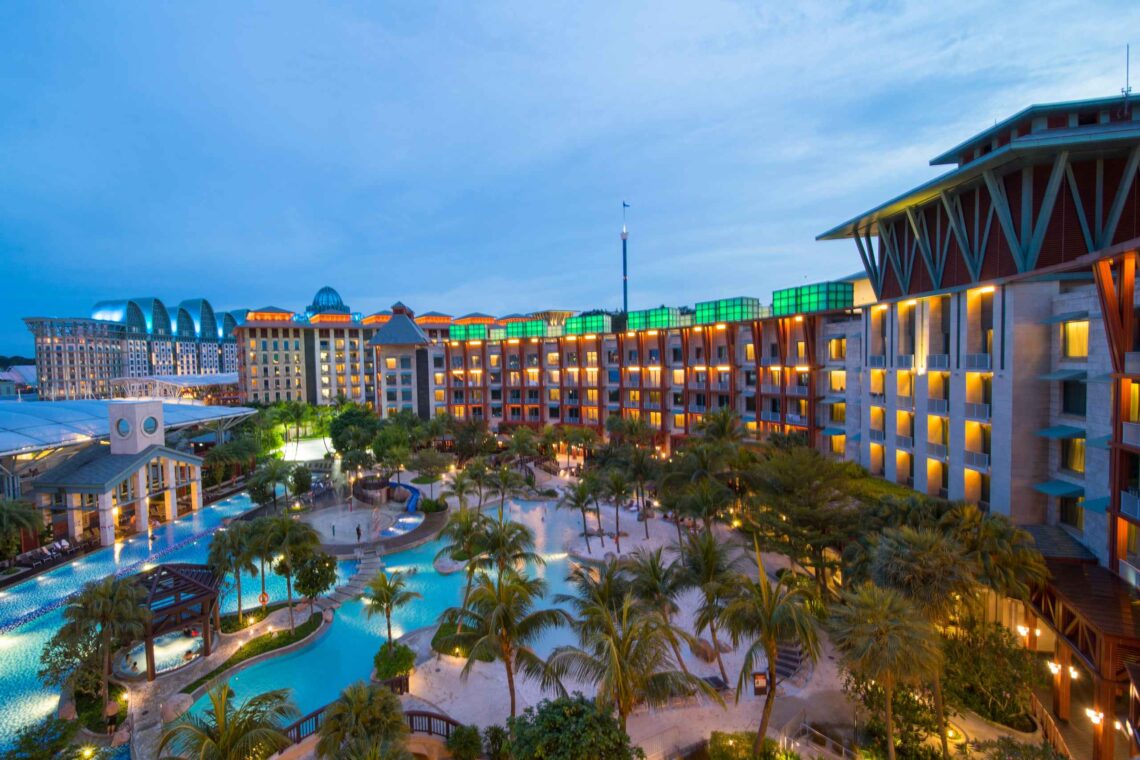 Luxury hotel resort with illuminated facade and outdoor pool at night Singapore