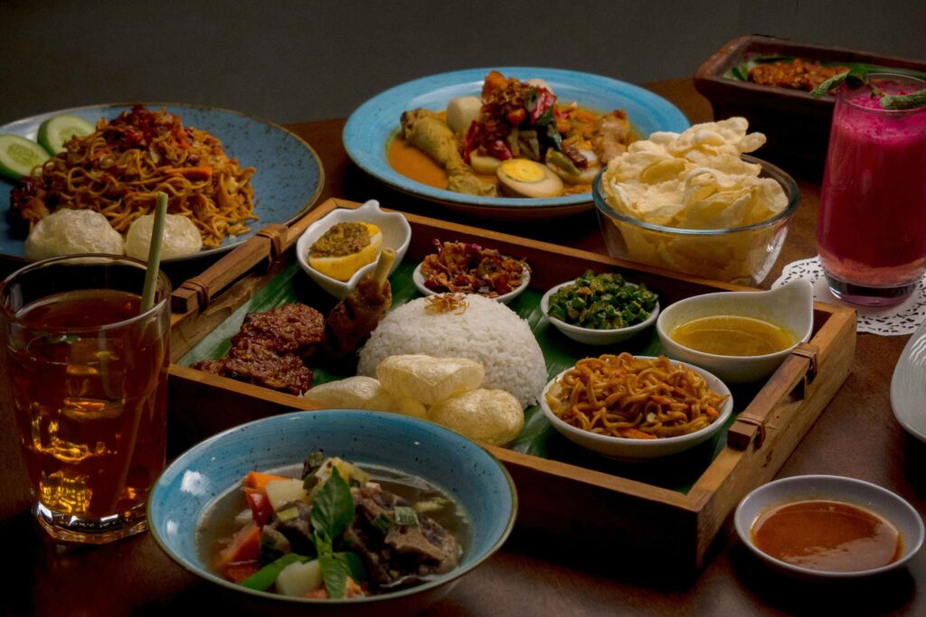 Traditional Singaporean dishes spread on a table including rice curry and side dishes