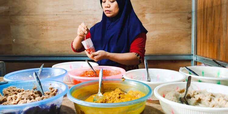 asian-woman-cooking-unsplash - SINwebzine A Peranakan cuisine cook presents traditional nyonya dishes at a heritage restaurant table in Singapore