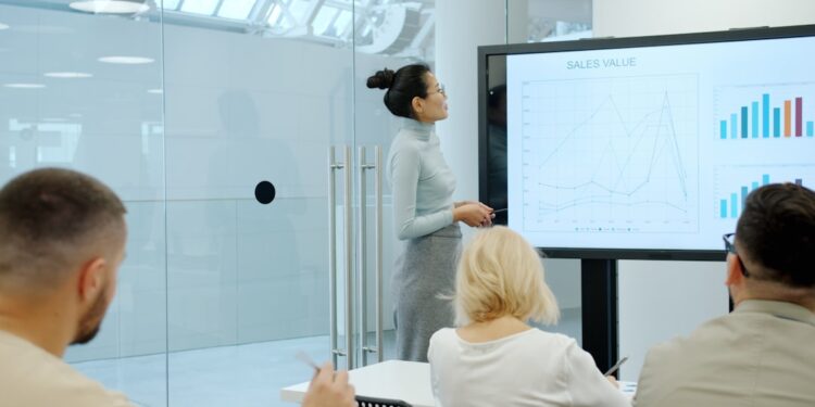 business-meeting-presentation-unsplash - SINwebzine A business reviews strategy documents at a high-rise office overlooking the Singapore headquarters district of Marina Bay