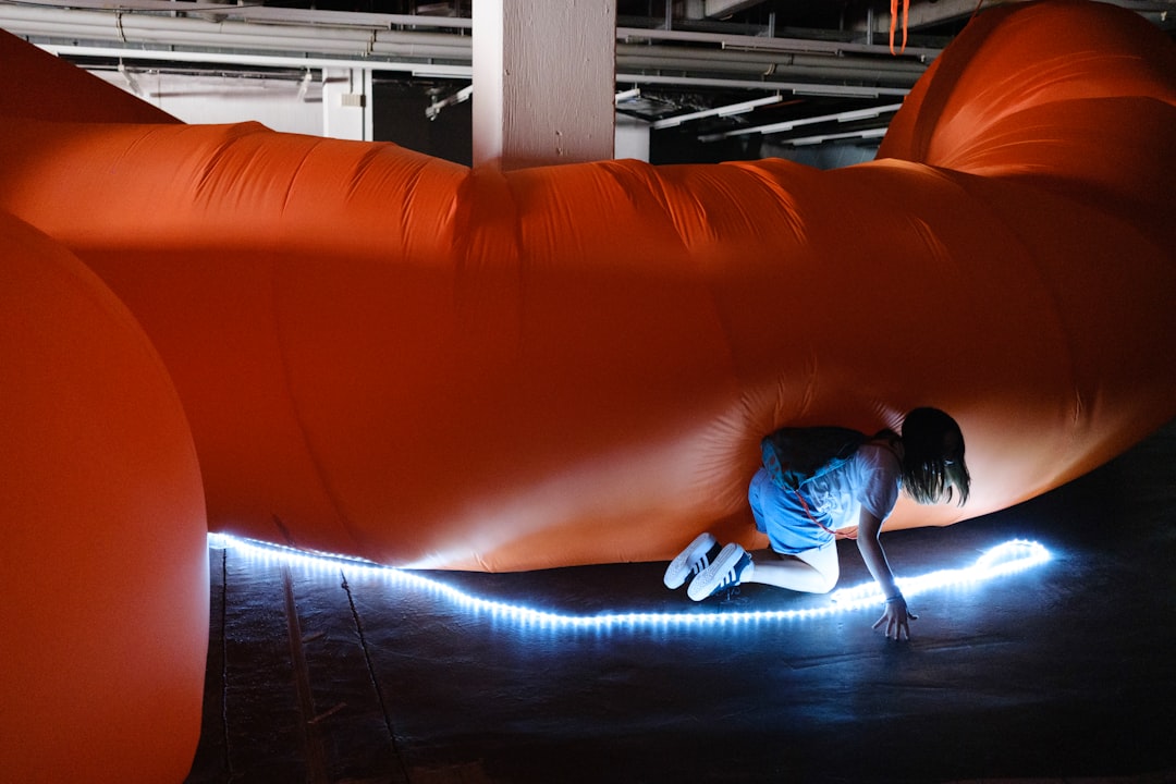 Two children navigating a foam obstacle course at a Singapore indoor playground while a parent watches from the side