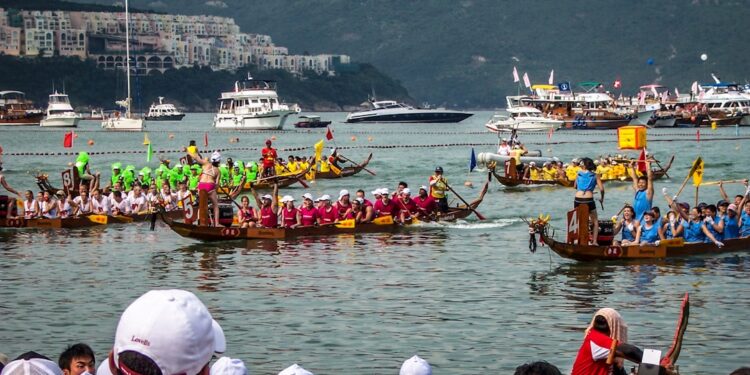 dragon-boat-racing-unsplash - SINwebzine A team of paddlers competing in June festivals Singapore dragon boat races at Bedok Reservoir, drums beating .