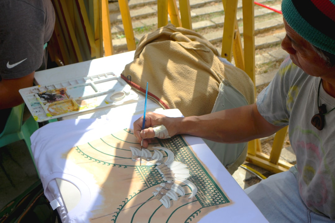 An illustrator signs a hand-drawn card for a visitor at the illustration arts fest 10th anniversary celebration
