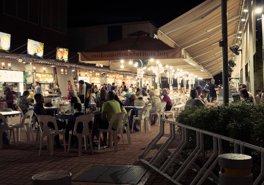 Friends enjoying late-night hawker food at a Singapore fan zones screening during the FIFA World Cup knockout rounds