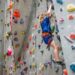 A young girl climbing a colourful structure at an indoor playground in Singa, pore, laughing with excitement