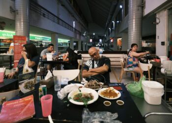 A Singaporean chef carefully plates a dish that blends local flavours with fine dining techniques.