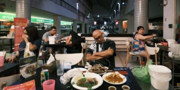 A Singaporean chef carefully plates a dish that blends local flavours with fine dining techniques.