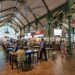 traveller-eating-hawker-centre-singapore-unsplash - SINwebzine A smiling traveller enjoys a budget getaway meal at a busy Singapore hawker centre