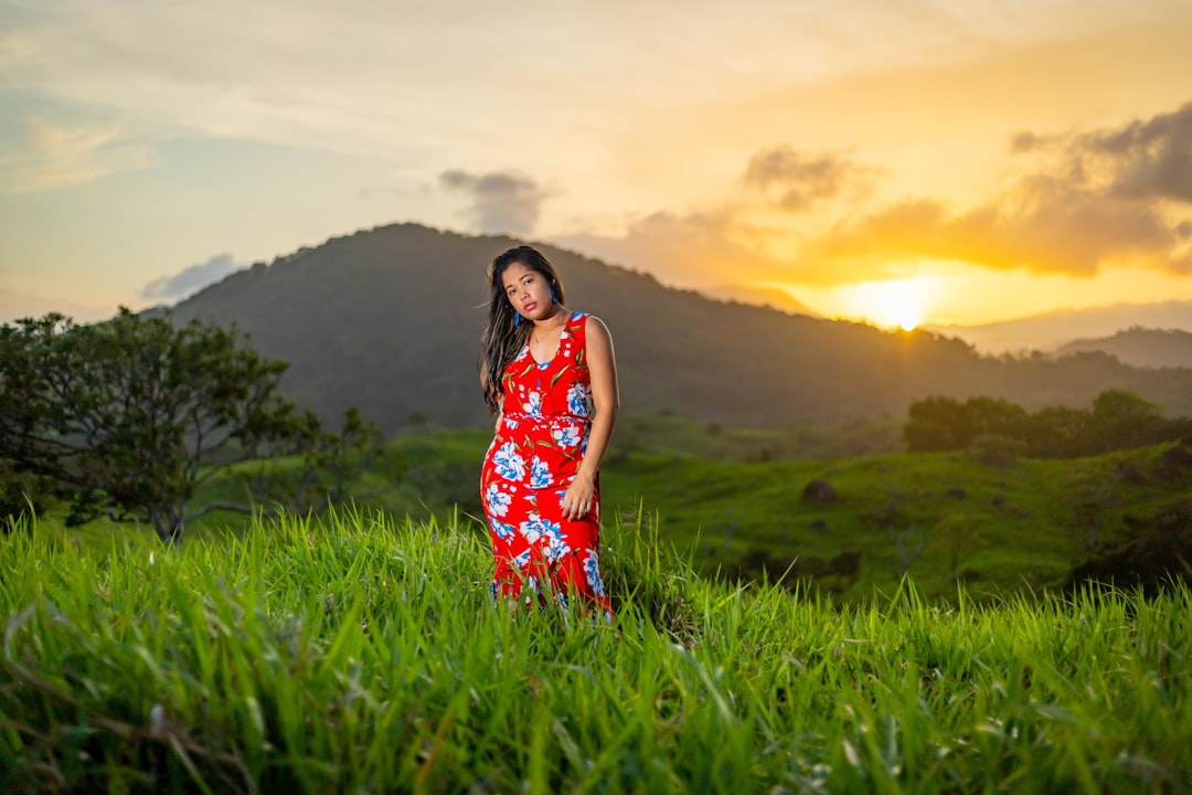 A woman wearing a vibrant batik slow fashion dress outdoors in Singapore, dressed for the city's warm and rainy July weather.