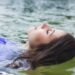 woman-relaxing-float-pod-unsplash - SINwebzine A woman resting peacefully inside a float therapy pod in a Singapore wellness studio, eyes closed in deep relaxation.