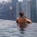 woman-relaxing-luxury-hotel-pool-singapore-unsplash - SINwebzine A woman relaxing by an infinity pool during a luxury staycation in Singapore with the city skyline in the background
