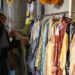 woman-shopping-ethical-clothing-boutique-unsplash - SINwebzine A woman browsing a rack of slow fashion garments in a Singapore boutique, choosing breathable pieces for the wet season.