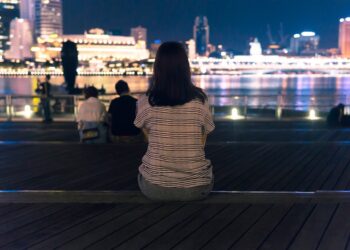 strolling the Marina Bay waterfront during June events in Singapore, surrounded by glowing light installations at night