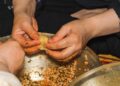A woman carefully wrapping zongzi rice dumplings at a Dragon Boat Festival workshop in Singapore