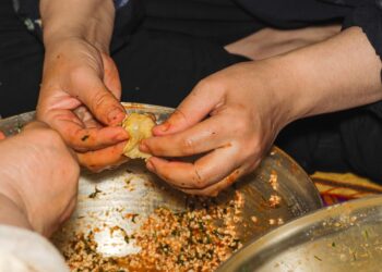 A woman carefully wrapping zongzi rice dumplings at a Dragon Boat Festival workshop in Singapore
