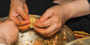 woman-wrapping-rice-dumpling-unsplash - SINwebzine A woman carefully wrapping zongzi rice dumplings at a Dragon Boat Festival workshop in Singapore