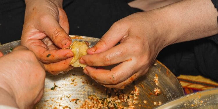 A woman carefully wrapping zongzi rice dumplings at a Dragon Boat Festival workshop in Singapore
