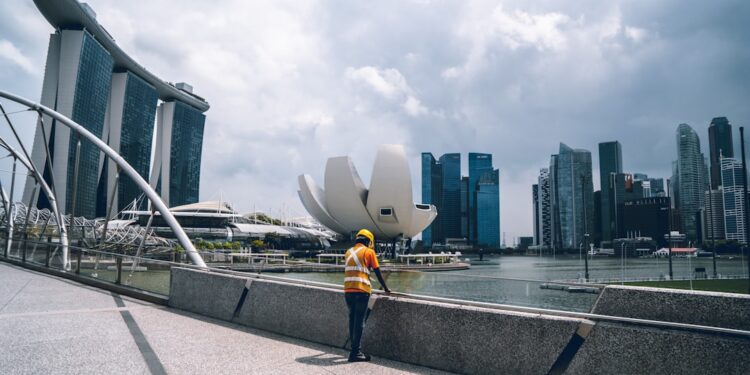 architect-reviewing-building-blueprints-singapore-unsplash - SINwebzine 一位新加坡建筑师审阅为应对中央商务区城市热岛效应而设计的建筑计划