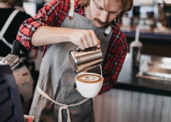 A skilled barista concentrates during a Singapore coffee championship latte art round