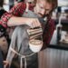 A skilled barista concentrates during a Singapore coffee championship latte art round
