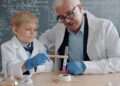 children-doing-science-experiment-classroom-unsplash - SINwebzine A child conducting hands-on science workshops at a classroom table wearing safety goggles and mixing colourful liquids.