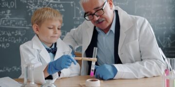 children-doing-science-experiment-classroom-unsplash - SINwebzine A child conducting hands-on science workshops at a classroom table wearing safety goggles and mixing colourful liquids.