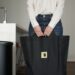 A woman sorting food scraps into a small bin for HDB composting in a Singapore kitchen