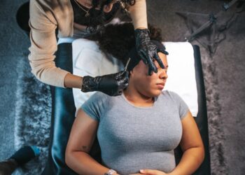 A board-certified dermatologist examines a patient's skin during a Singapore dermatology consultation in a clinical setting