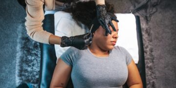 dermatologist-examining-patient-skin-unsplash - SINwebzine A board-certified dermatologist examines a patient's skin during a Singapore dermatology consultation in a clinical setting