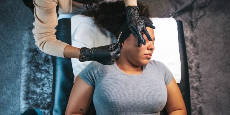 A board-certified dermatologist examines a patient's skin during a Singapore dermatology consultation in a clinical setting