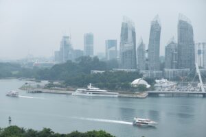 A traveller on a ferry heading to the southern islands of Singapore, with the city skyline in the background