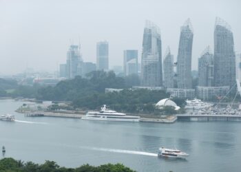 A traveller on a ferry heading to the southern islands of Singapore, with the city skyline in the background