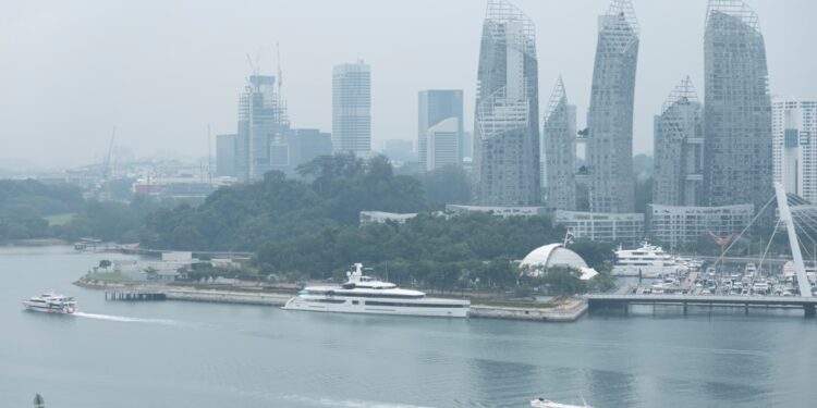 A traveller on a ferry heading to the southern islands of Singapore, with the city skyline in the background