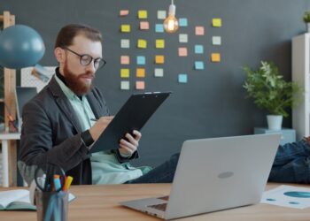 A first-time founder reviewing Singapore grants on a laptop in a Singapore co-working office