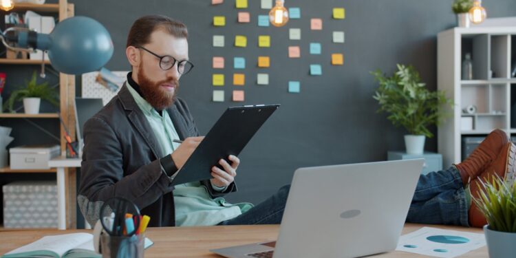 A first-time founder reviewing Singapore grants on a laptop in a Singapore co-working office
