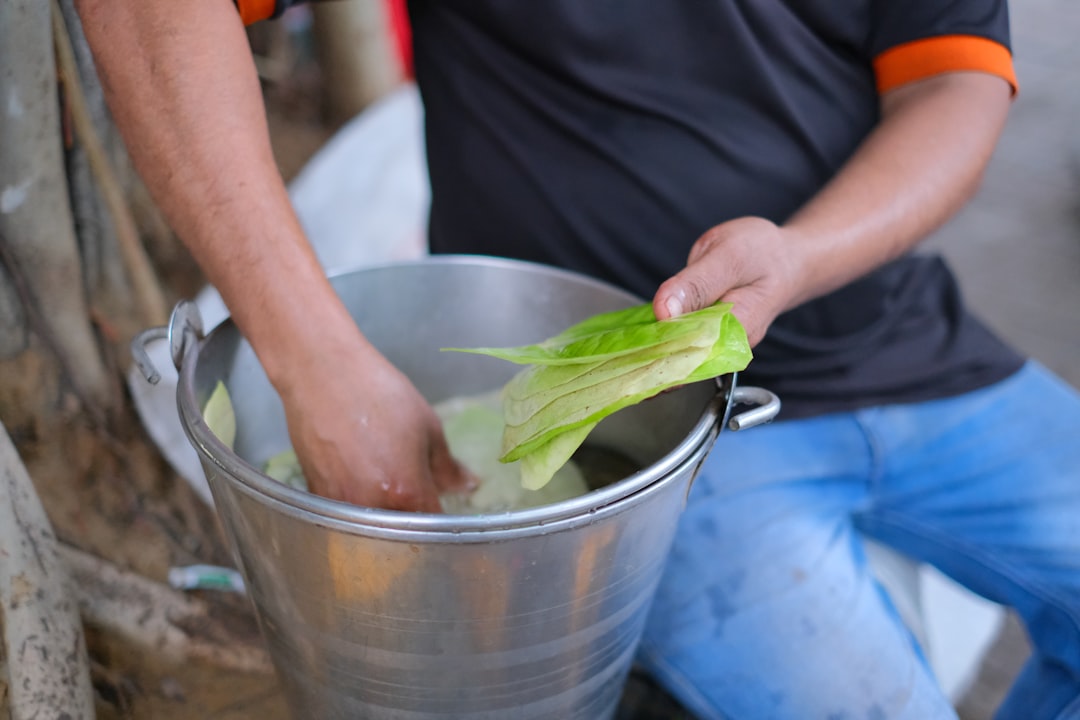 A person holding a sealed bokashi bucket used for HDB composting in a compact apartment