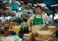 singapore-hawker-woman-serving-rice-unsplash - SINwebzine A hawker stallholder in Singapore serves Hainanese chicken rice, one of the most beloved National Day dishes on the island.