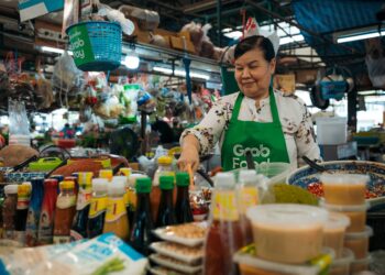 A hawker stallholder in Singapore serves Hainanese chicken rice, one of the most beloved National Day dishes on the island.