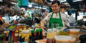 singapore-hawker-woman-serving-rice-unsplash - SINwebzine A hawker stallholder in Singapore serves Hainanese chicken rice, one of the most beloved National Day dishes on the island.