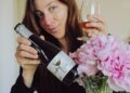 sommelier-pouring-wine-in-cellar-unsplash - SINwebzine A sommelier pours a glass of red wine inside a private cellar in Singapore, with rows of bottles visible behind her