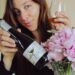 sommelier-pouring-wine-in-cellar-unsplash - SINwebzine A sommelier pours a glass of red wine inside a private cellar in Singapore, with rows of bottles visible behind her