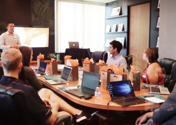 A Singapore startup founder reviews equity crowdfunding platform options on a laptop during a funding meeting