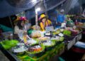 A chef preparing traditional hawker dishes at a Singapore food festival stall, showcasing local culinary heritage