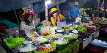 A chef preparing traditional hawker dishes at a Singapore food festival stall, showcasing local culinary heritage