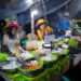 A chef preparing traditional hawker dishes at a Singapore food festival stall, showcasing local culinary heritage