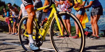 tour-de-france-unsplash - SINwebzine A cyclist racing at speed through city streets during the Singapore criterium, with spectators watching from the roadside