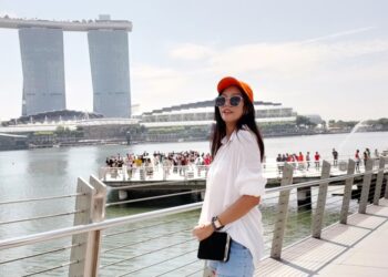 A traveller carrying a backpack boards a ferry at a Singapore terminal, ready for one of many weekend escapes from Singapore
