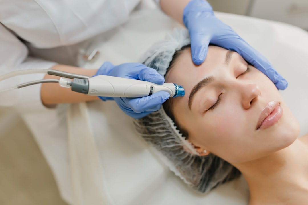 A woman receiving laser pigmentation treatment at a Singapore dermatology clinic with a specialist present